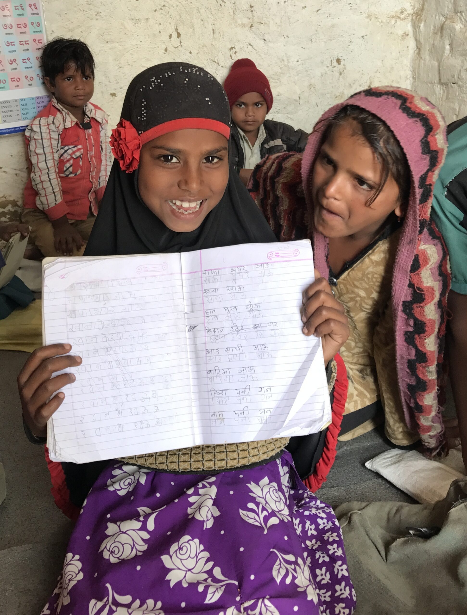 girl at Bridge School for child laborers and children at risk for child labor, holding school work